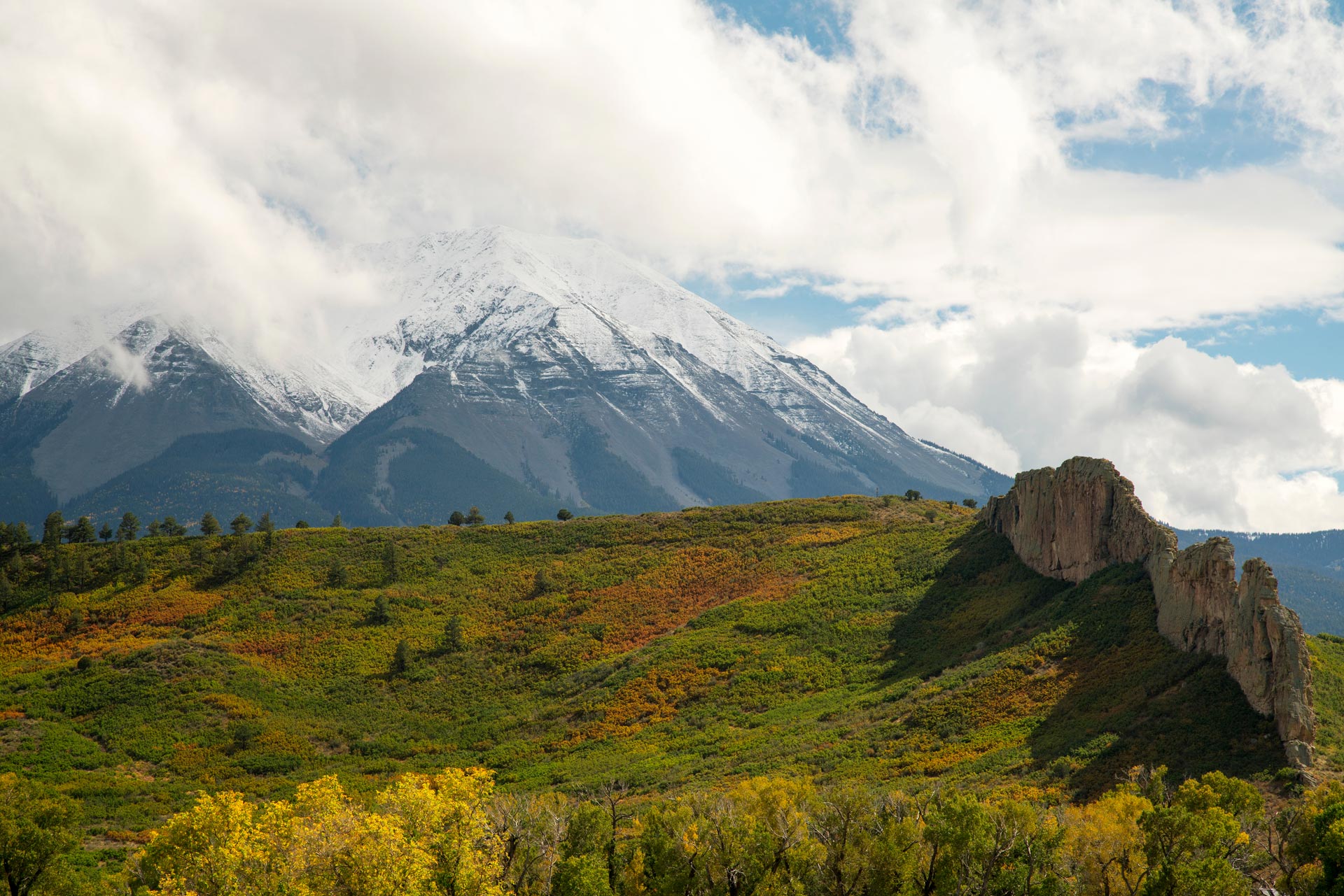 West Spanish Peak capped in snow with fall colors and a dike in the foreground
